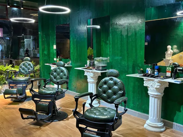 Green tufted barber chairs with Corinthian columns