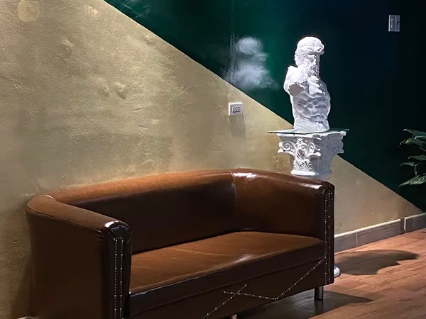 Waiting area with leather sofa and bust statue